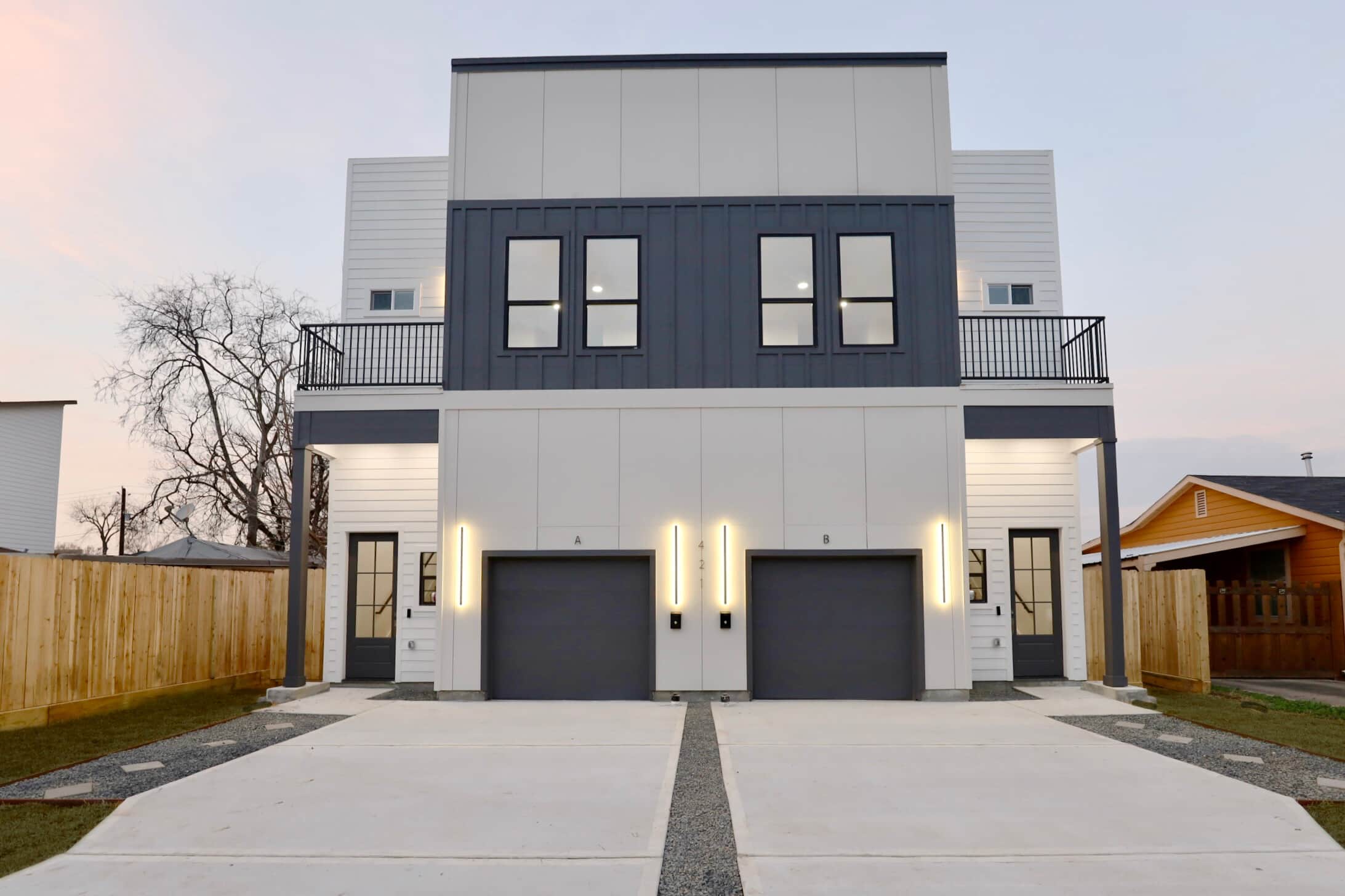 421 E 41st at twilight: the duplex's front elevation with LED accents and paired garages.