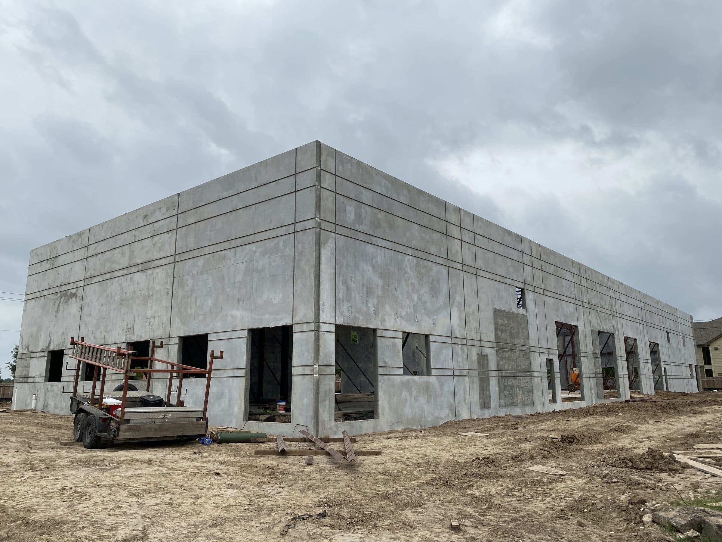 Tilt-wall concrete panels standing on the slab with reveal-line grid