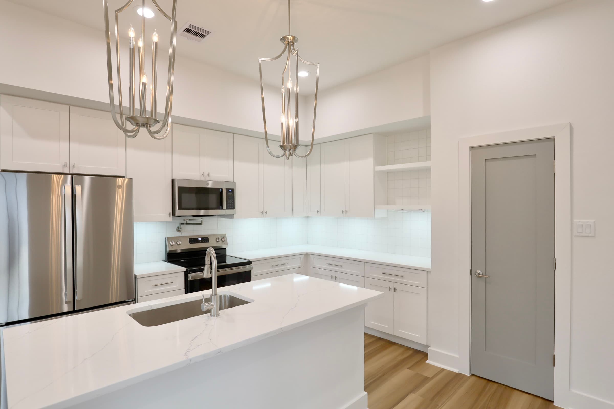 Open kitchen with pendants and waterfall-edge island